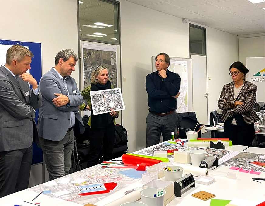 Werkstattgespräch zur Stadtentwicklung Fachleute besprechen städtebauliche Planungen anhand von Karten und Entwürfen in einem Workshopraum